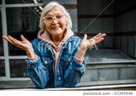 Happy mature woman standing outdoors stock photo Happy mature woman standing outdoors stock photo 61995646