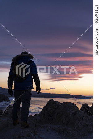 Happy man standing on cliff Happy man standing on cliff 62001113
