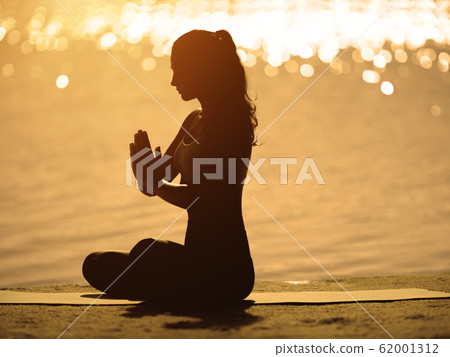 Silhouette of Woman in Meditation on the Beach Silhouette of Woman in Meditation on the Beach 62001312