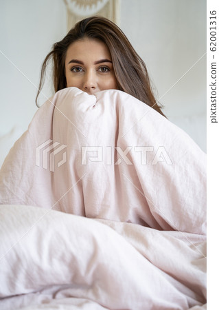 Young Caucasian woman sitting alone in bed Young Caucasian woman sitting alone in bed 62001316
