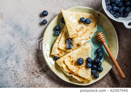Crepes with blueberries and honey, top view. Crepes with blueberries and honey, top view. 62007040