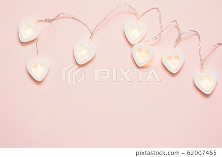 Heart shape garland on a pink pastel background. Heart shape garland on a pink pastel background. 62007465