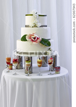 Big wedding cake with three storey decorated by 62007943