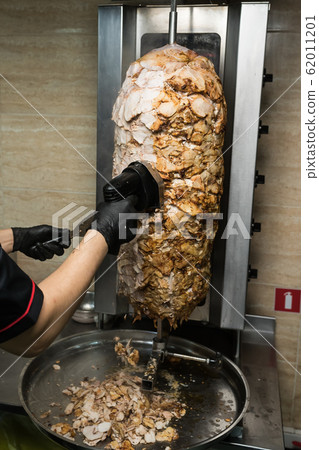 Chef hands chop chicken for doner kebab 62011201