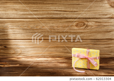 Gift box with ribbon on wooden background top view 62013304