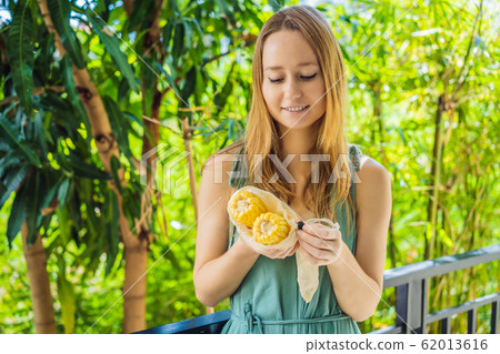 Corn in a reusable bag in the hands of a young woman. Zero waste concept 62013616