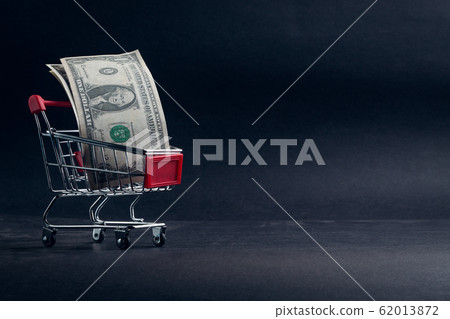 Shopping cart and dollar banknotes on dark 62013872
