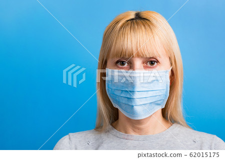Portrait of woman wearing medical mask at blue Portrait of woman wearing medical mask at blue 62015175