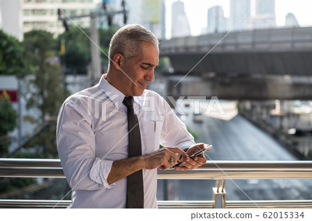 Old American businessman use smartphone in city Old American businessman use smartphone in city 62015334
