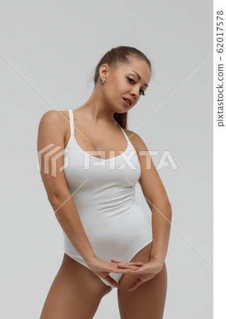 Crop gorgeous woman taking off swimsuit Crop gorgeous woman taking off swimsuit 62017578