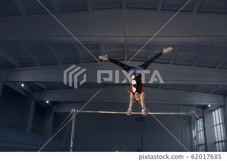Little male gymnast training in gym, flexible and active 62017685
