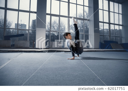 Little male gymnast training in gym, flexible and active 62017751