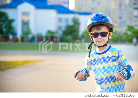 Little boy riding on rollers in the summer in the 62018166