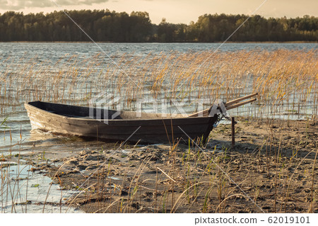 Boat moored on the mudy shore lake 62019101