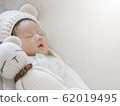 Closeup a baby sleeping comfortably on sofa with bear doll 62019495