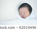 Closeup a baby sleeping comfortably on the bed 62019496