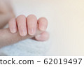 Closeup baby hand is holding the mother's finger with copy space 62019497