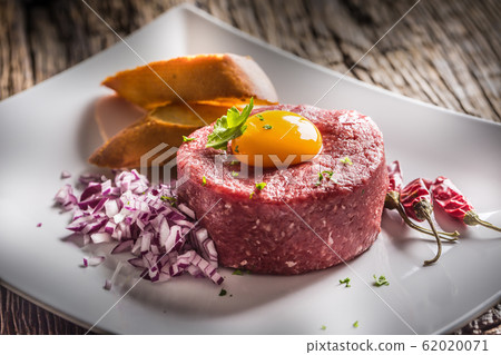Beef tartare with egg yolk red onion chili peppers 62020071