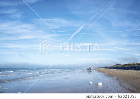 Horseback riders on a beach in the summer Horseback riders on a beach in the summer 62021355