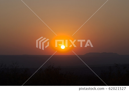 Red sunset over a large area with hills Red sunset over a large area with hills 62021527