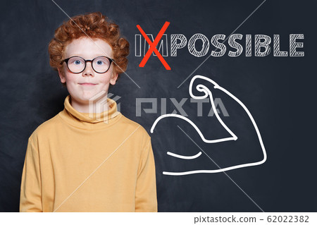 Child in glasses and text possible on chalkboard 62022382