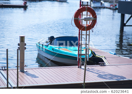Small motor boat at anchor by rope in Replot pier 62023641