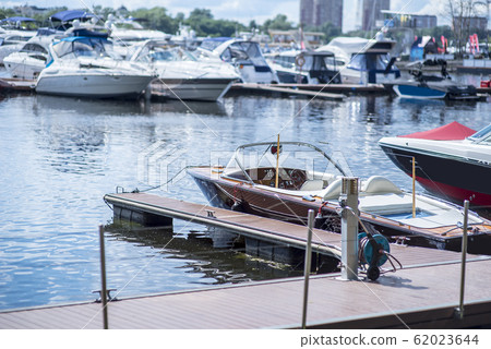 Motor boat anchored on a rope at the pier against 62023644
