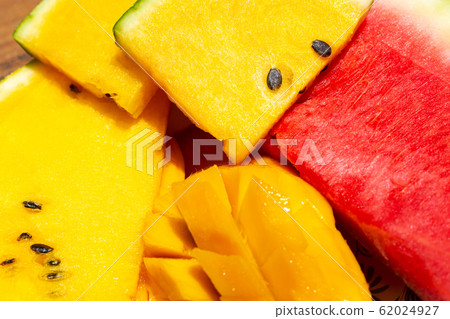 Closeup ripe juicy sliced fruits of mango and red 62024927