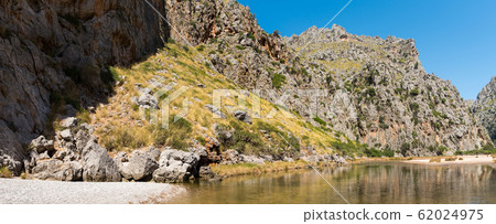 Beautiful wide summer panoramic nature landscape. River Torrent de Pareis between rocky mountains. Popular tourist destinations Sa Calobra port village, Escorca, Majorca, Balearic Islands, Spain 62024975