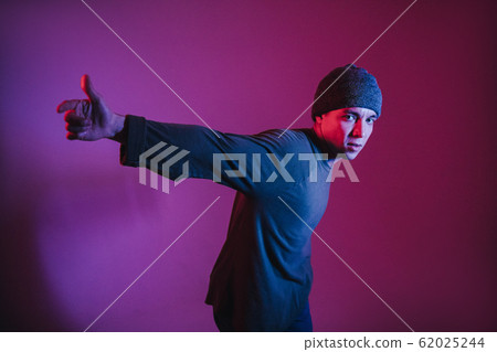 Young Man in a Jumper Dancing Contemporary Dance in Studio. Breakdancing. Dance School Poster. Copy Space. Battle competition announcement. Pink and Blue Background. Young Man in a Jumper Dancing Contemporary Dance in Studio. Breakdancing. Dance School Poster. Copy Space. Battle competition announcement. Pink and Blue Background. 62025244