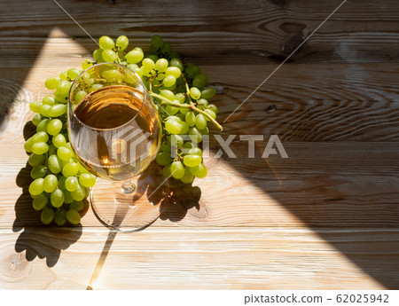 White Wine Glass on Ripe Green Grapes Background White Wine Glass on Ripe Green Grapes Background 62025942