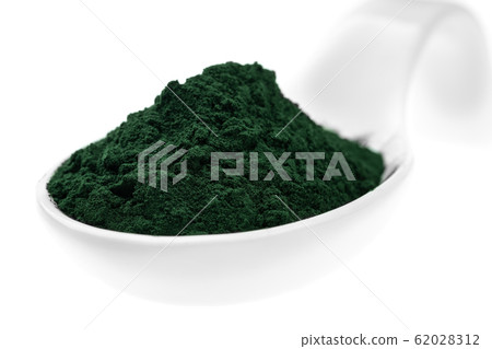 Vitamin and mineral supplements for vegetarians spirulina powder in a ceramic spoon, close-up. 62028312