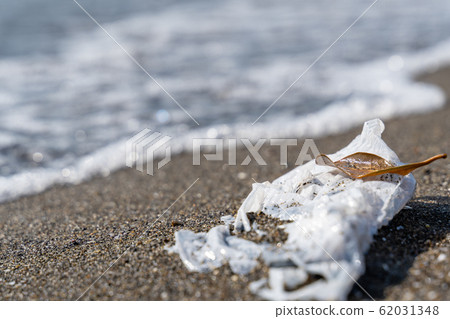 Shopping bag launched on a sandy beach marine garbage 62031348