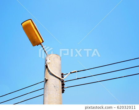 Street lamp and cable on post Old yellow street lights for safety at night for safety On a bright blue sky background With a copy area. Selective focus Street lamp and cable on post Old yellow street lights for safety at night for safety On a bright blue sky background With a copy area. Selective focus 62032011