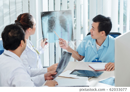 Medical specialists discussing x-ray Medical specialists discussing x-ray 62033077