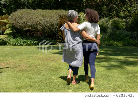Two women walking in the garden Two women walking in the garden 62033423