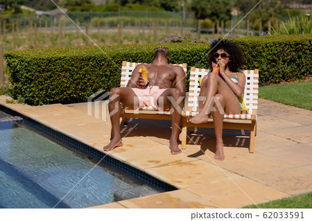 Young couple relaxing near swimming pool on a sunny day 62033591
