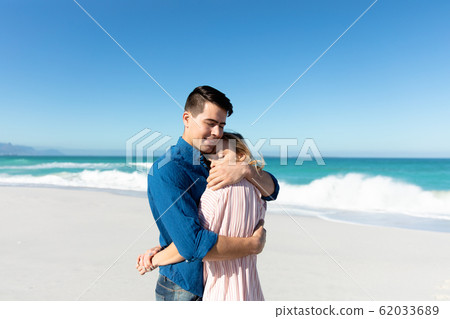 Young couple hugging at the beach Young couple hugging at the beach 62033689