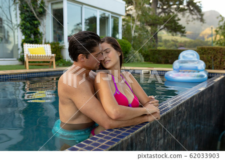 Couple in swimming pool taking selfie. Stock Photo by ©halfpoint 100263108