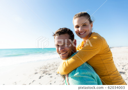 Couple having fun at the beach 62034003
