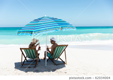 Young couple relaxing at the beach Young couple relaxing at the beach 62034004