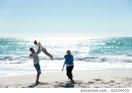 Parents and children having fun at the beach 62034019