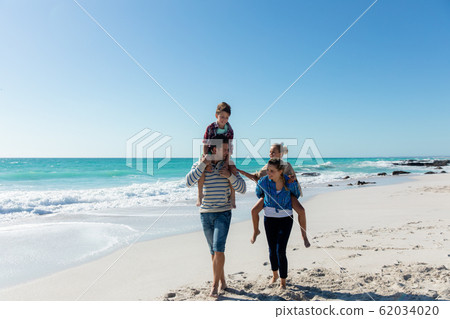 Parents and children having fun at the beach 62034020
