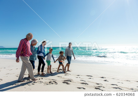 Family walking together at the beach Family walking together at the beach 62034068