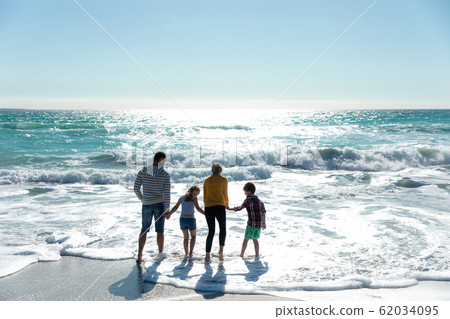 Parents and children walking in the water Parents and children walking in the water 62034095