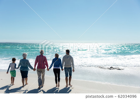 Family walking towards the water Family walking towards the water 62034096