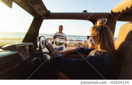 Couple with car at the beach 62034124