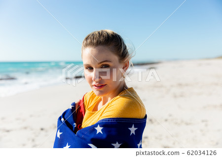Woman with american flag at the beach Woman with american flag at the beach 62034126