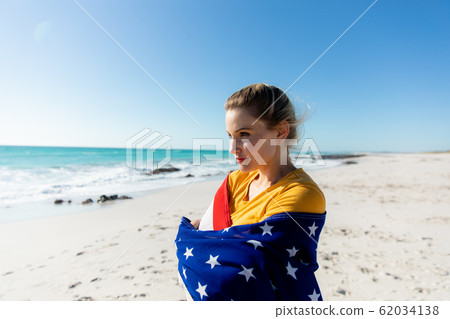 Woman with american flag at the beach 62034138