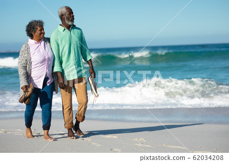 Old couple walking at the beach Old couple walking at the beach 62034208